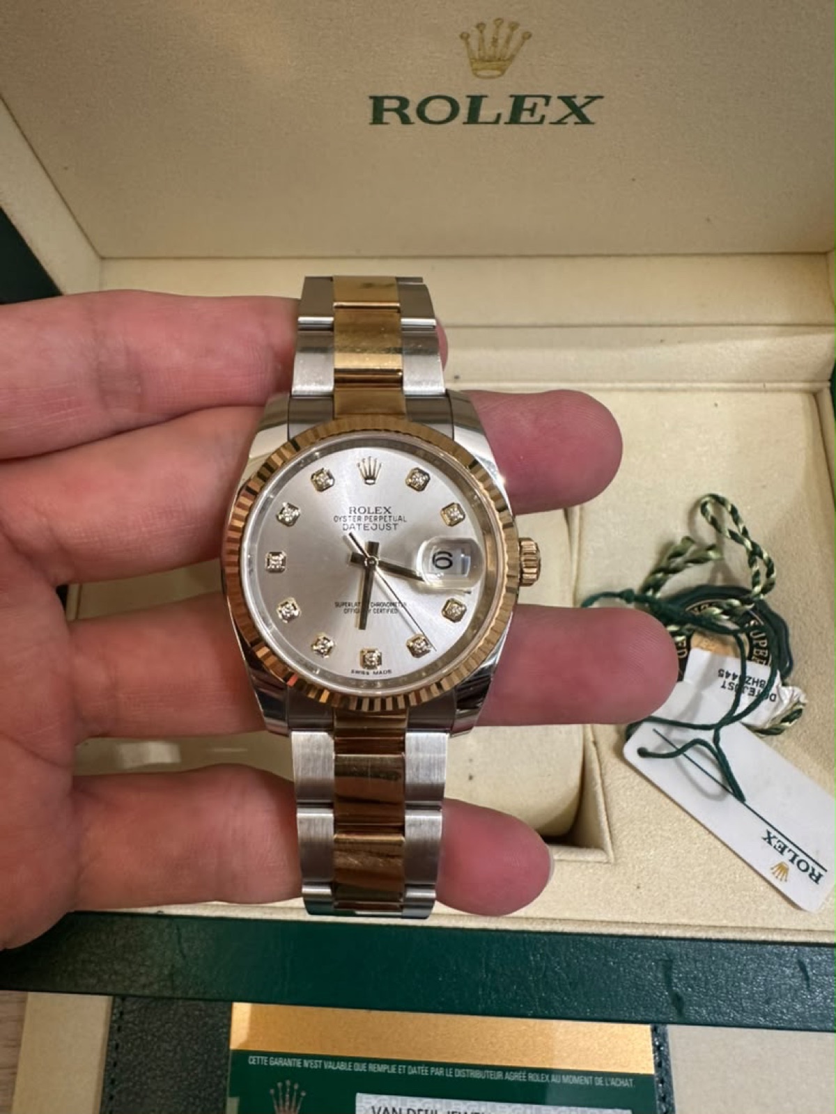 Rolex Datejust, two-tone with diamond markers, held in hand